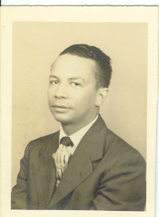 Sepia studio portrait of Dr. Gordon A. Rodgers Jr. in a dark pinstriped suit and patterned tie.